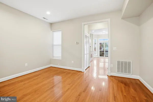a view of empty room with wooden floor