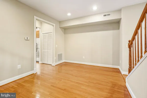 a view of an empty room with wooden floor