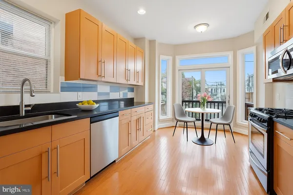 a kitchen with granite countertop a stove a sink a counter space and cabinets