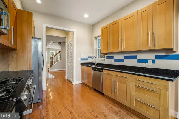 a kitchen with granite countertop wooden cabinets a sink and a stove
