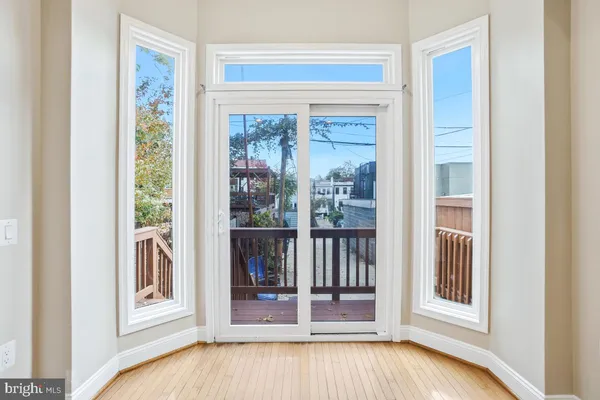 a view of a bedroom with wooden floor and windows