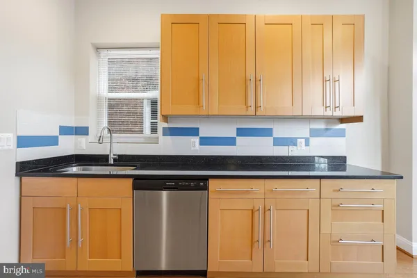 a kitchen with granite countertop white cabinets and sink