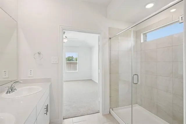 a bathroom with a bathtub shower sink vanity and mirror