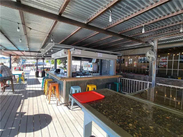 a view of a swimming pool with a couches chairs and wooden roof