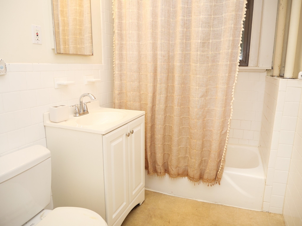 1386 Beacon Street, Unit 4 Brookline, MA 02446 - Photo 6 of 7 a bathroom with a sink a toilet and shower curtain