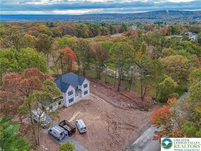 an empty room with wooden floor chandelier and windows