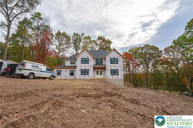 a front view of a house with a yard and trees