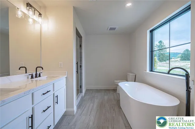 a kitchen with white cabinets appliances wooden floor and a window