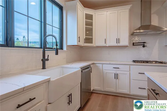 an empty room with wooden floor fireplace and windows
