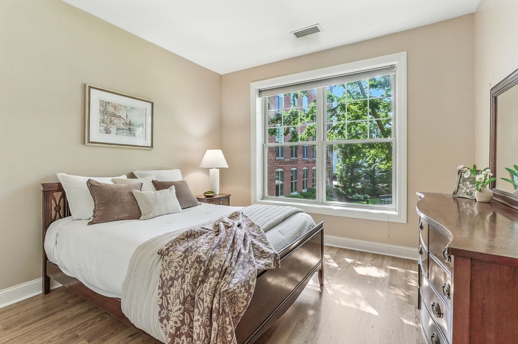 248 Albion Street, Unit 211 Wakefield, MA 01880 - Photo 14 of 24 a bed sitting in a bedroom next to a window