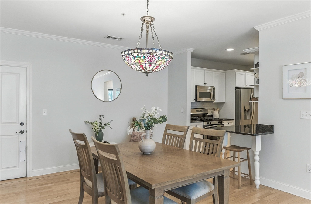 248 Albion Street, Unit 211 Wakefield, MA 01880 - Photo 5 of 24 a view of a dining room with furniture and wooden floor
