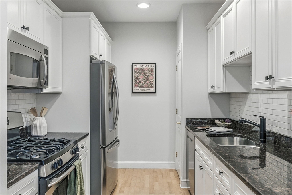 248 Albion Street, Unit 211 Wakefield, MA 01880 - Photo 6 of 24 a kitchen with stainless steel appliances granite countertop a stove and a refrigerator