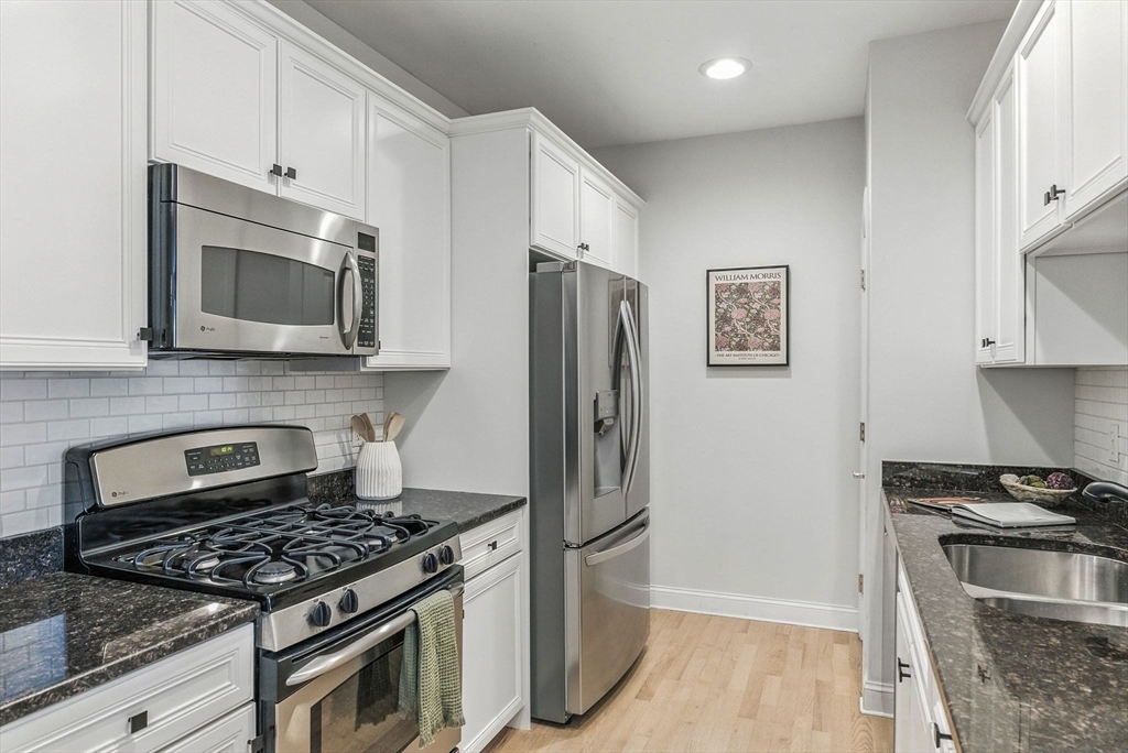 248 Albion Street, Unit 211 Wakefield, MA 01880 - Photo 8 of 24 a kitchen with stainless steel appliances granite countertop a stove and a refrigerator