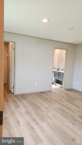 a view of empty room with wooden floor and window