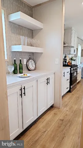 a kitchen with white cabinets and window