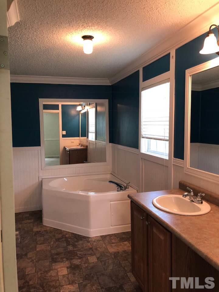 855 Chub Lake Loop Road Roxboro, NC 27574 - Photo 12 of 24 a spacious bathroom with a tub sink and mirror