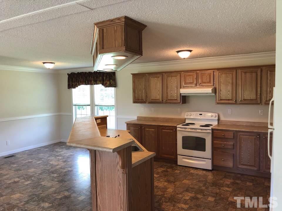 855 Chub Lake Loop Road Roxboro, NC 27574 - Photo 5 of 24 a kitchen with stainless steel appliances kitchen island granite countertop a stove a sink and a microwave