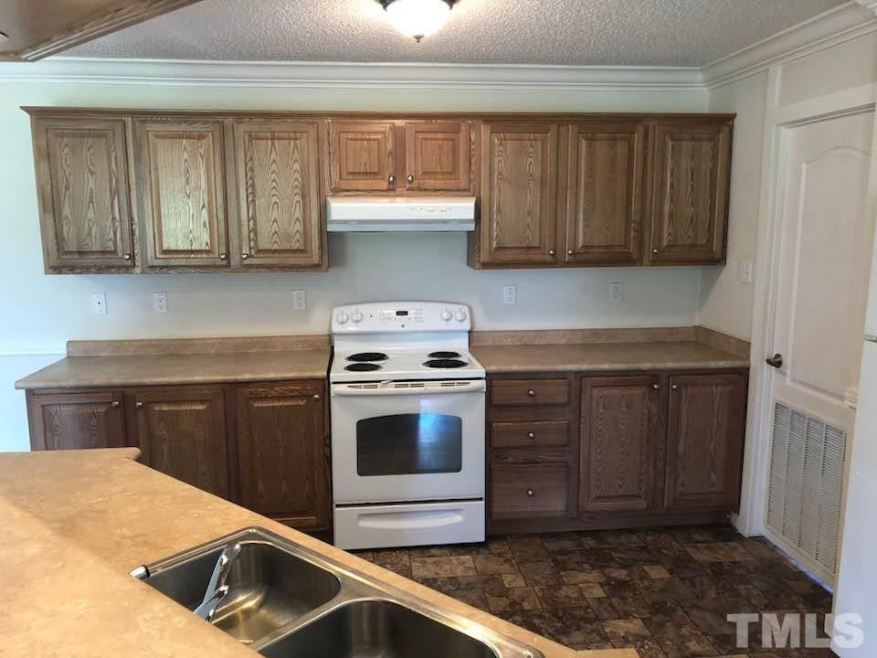 855 Chub Lake Loop Road Roxboro, NC 27574 - Photo 8 of 24 a kitchen with stainless steel appliances granite countertop a sink and a stove top oven
