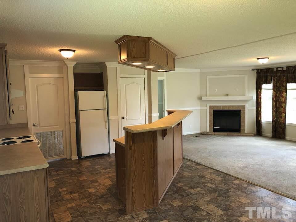 855 Chub Lake Loop Road Roxboro, NC 27574 - Photo 9 of 24 a view of a kitchen with a sink and a fireplace