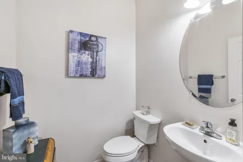 a bathroom with a toilet a sink and mirror