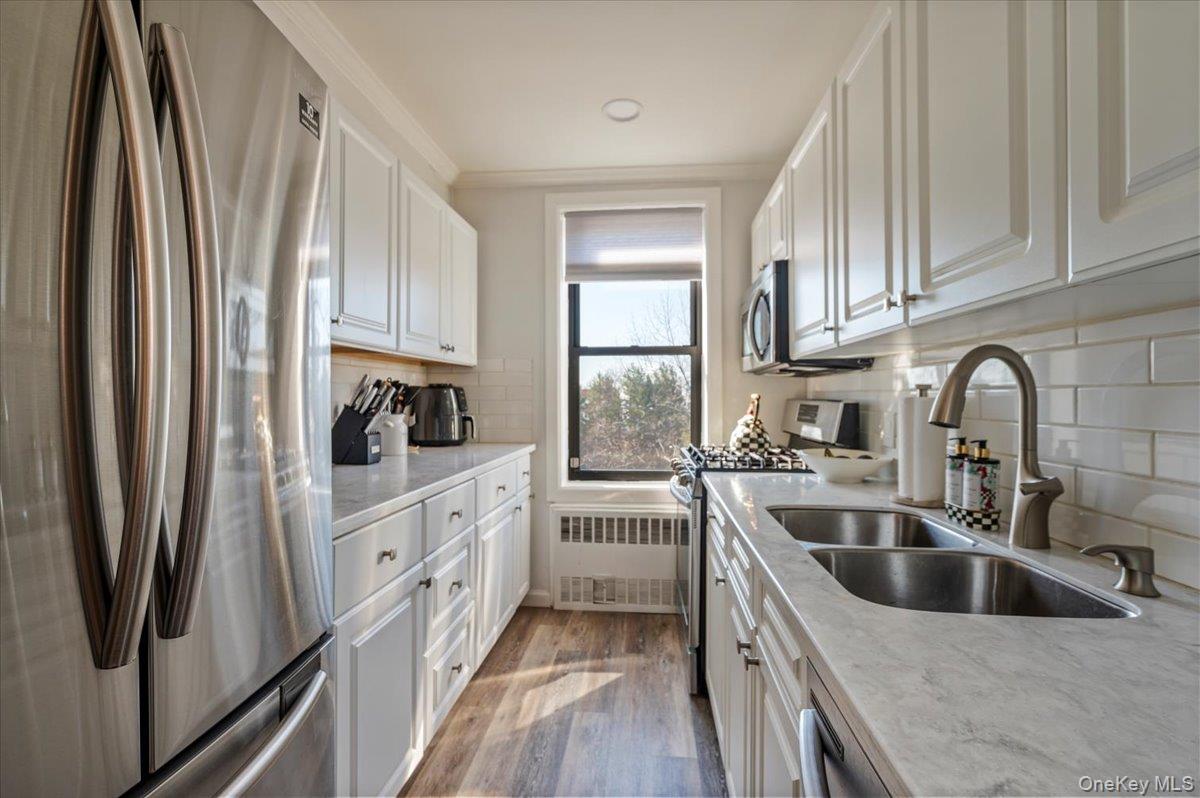 1 Remsen Road, Unit 4J Yonkers, NY 10710 - Photo 8 of 15 a kitchen with white cabinets and stainless steel appliances