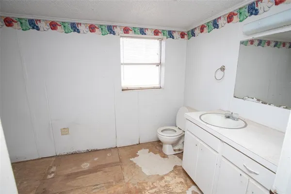 a bathroom with a sink vanity mirror and toilet