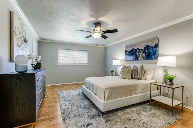 a bedroom with a bed lamp and a potted plant