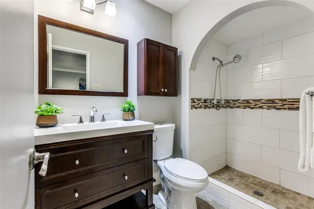 a bathroom with a granite countertop toilet sink and mirror