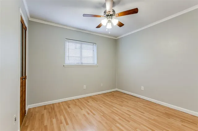 an empty room with a window and a ceiling fan