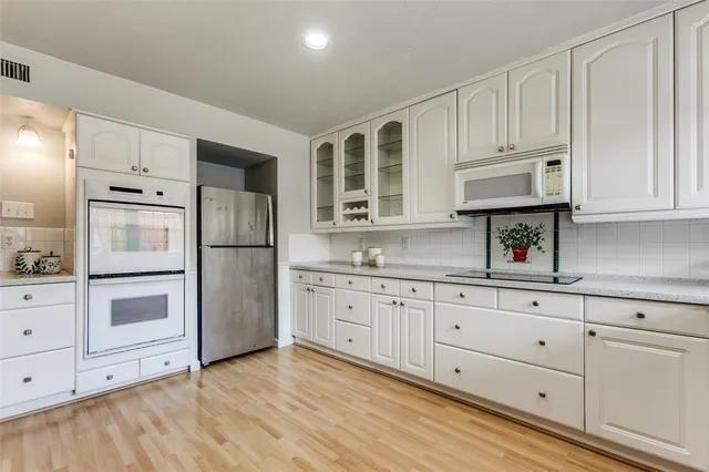 a kitchen with granite countertop white cabinets and refrigerator