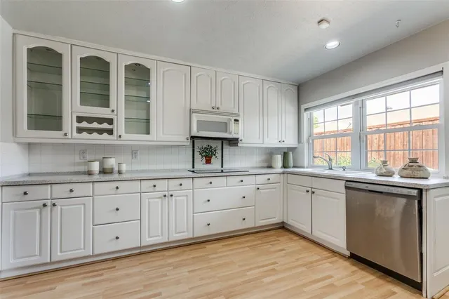 a kitchen with cabinets appliances and a window