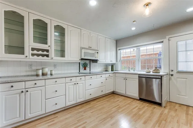a kitchen with granite countertop white cabinets and white appliances