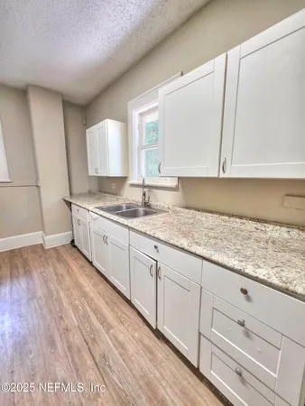 a kitchen with granite countertop white cabinets and white appliances