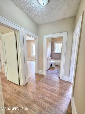 a view of a room with wooden floor and a bathroom