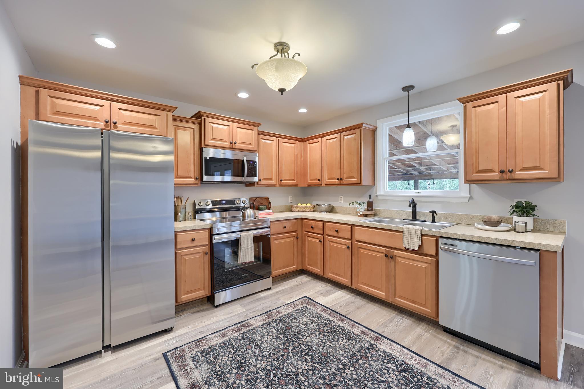 470 Oak Hollow Road Red Lion, PA 17356 - Photo 17 of 84 a kitchen with stainless steel appliances granite countertop a refrigerator a sink dishwasher a stove and white cabinets with wooden floor