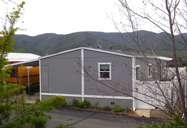 a view of a house with a yard and mountain view in back