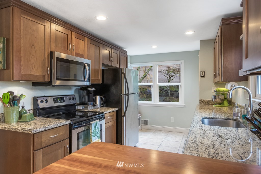 6715 35th Avenue Southwest Seattle, WA 98126 - Photo 11 of 31 a kitchen with stainless steel appliances granite countertop a stove top oven a sink dishwasher a refrigerator and a microwave