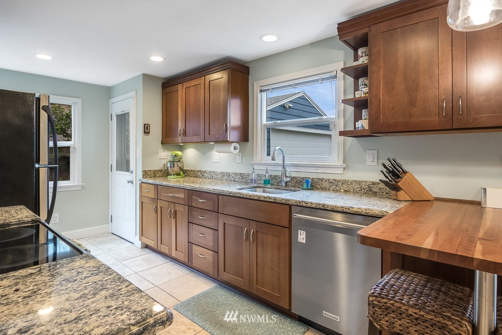 6715 35th Avenue Southwest Seattle, WA 98126 - Photo 12 of 31 a kitchen with stainless steel appliances granite countertop a sink stove and cabinets