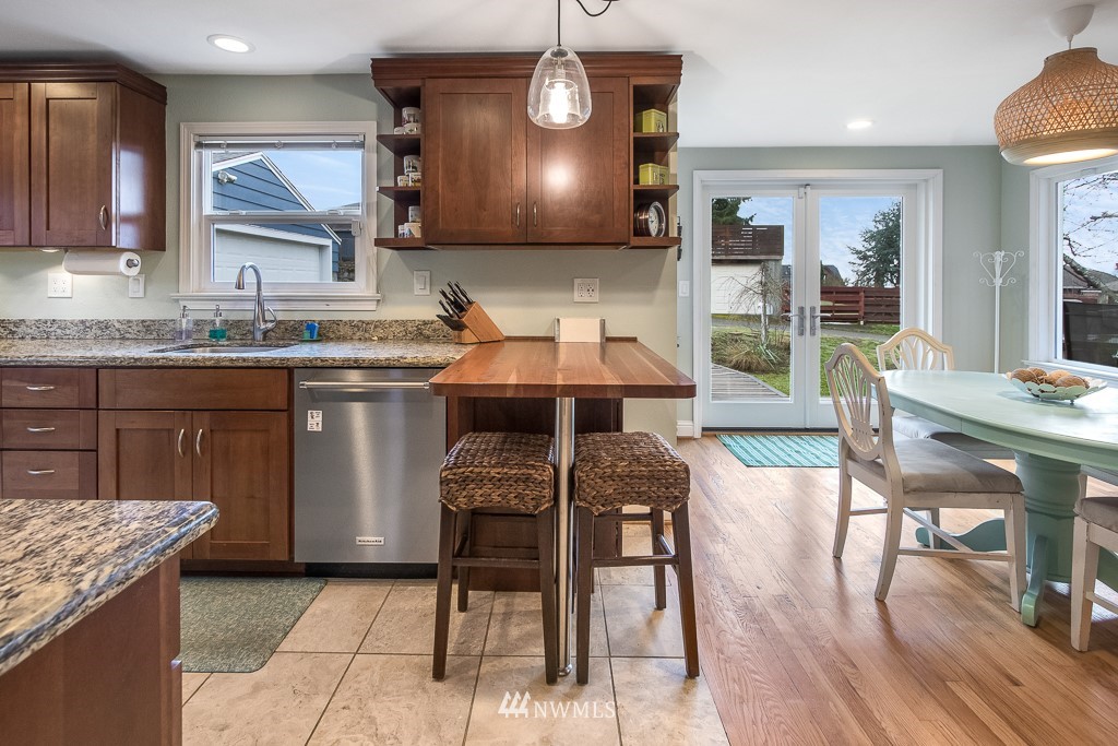 6715 35th Avenue Southwest Seattle, WA 98126 - Photo 9 of 31 a kitchen with stainless steel appliances granite countertop table chairs sink and cabinets