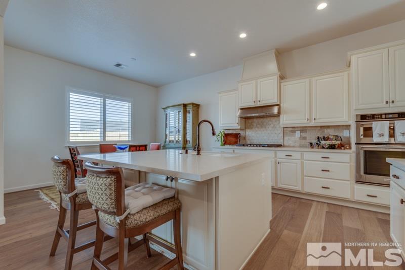2537 Titanium Crest Drive Reno, NV 89521 - Photo 9 of 26 a kitchen with white cabinets and stainless steel appliances