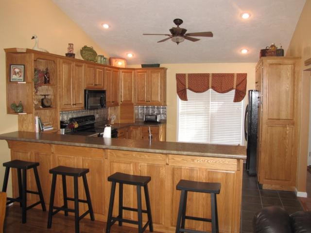1207 Rabbit Run Road Goodview, VA 24095 - Photo 8 of 36 a kitchen with stainless steel appliances kitchen island granite countertop a table chairs microwave and sink
