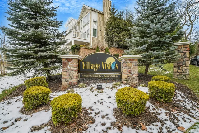 a view of a street with potted plants and large trees