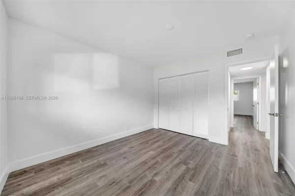 a view of a room with wooden floor and brick walls