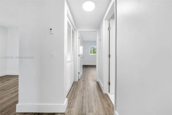 a view of a hallway with wooden floor and staircase