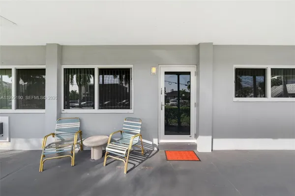 a backyard of a house with sofas table and chairs
