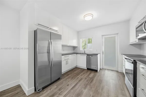 a kitchen with a refrigerator and a stove top oven