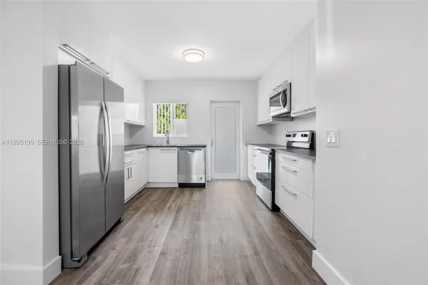 a kitchen with stainless steel appliances a refrigerator and a stove top oven