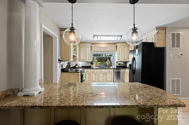 a kitchen with kitchen island granite countertop a table and chairs in it