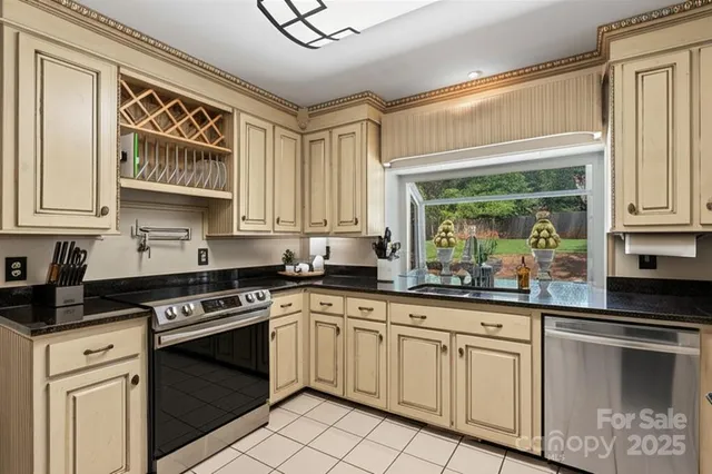 a kitchen with stainless steel appliances granite countertop a stove a sink and a microwave