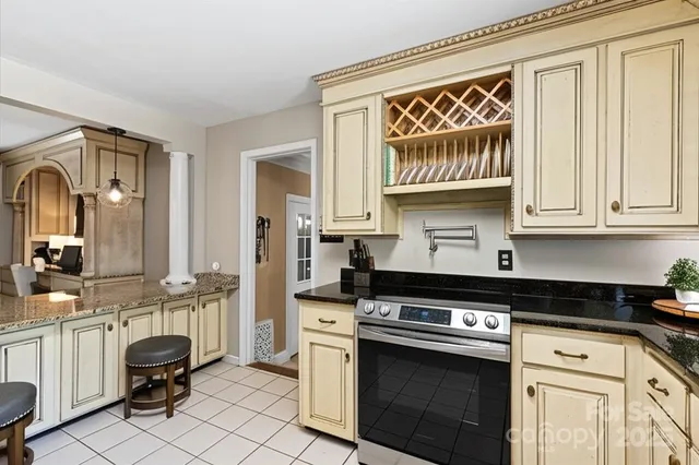 a kitchen with granite countertop a stove and cabinets